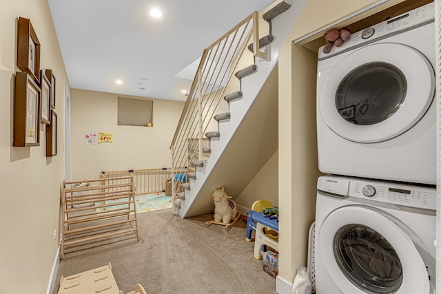 clothes washing area with carpet flooring and stacked washer / drying machine