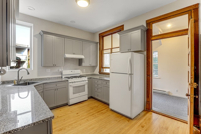 kitchen featuring white appliances, sink, and a wealth of natural light