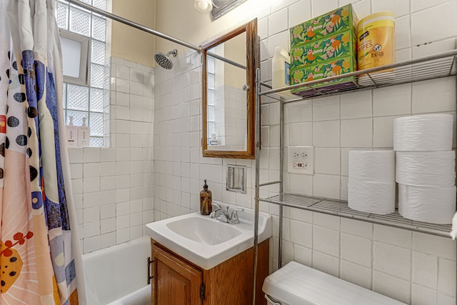 full bathroom with vanity, shower / bathtub combination with curtain, toilet, and tile walls