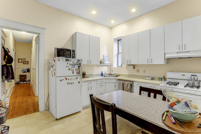 kitchen featuring white cabinets, white appliances, light hardwood / wood-style flooring, and sink