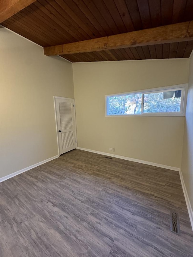 empty room featuring hardwood / wood-style floors, lofted ceiling with beams, and a wealth of natural light