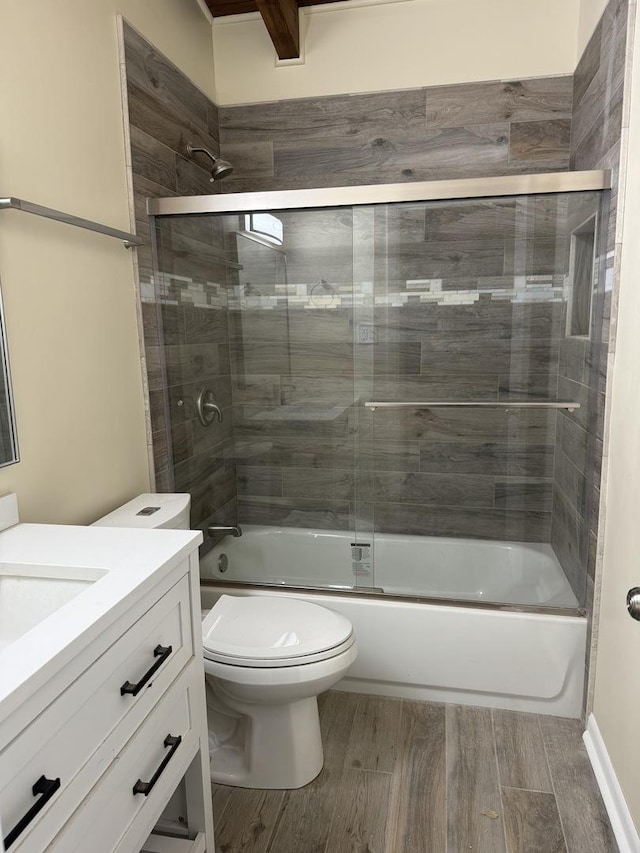 full bathroom featuring hardwood / wood-style flooring, vanity, toilet, and bath / shower combo with glass door