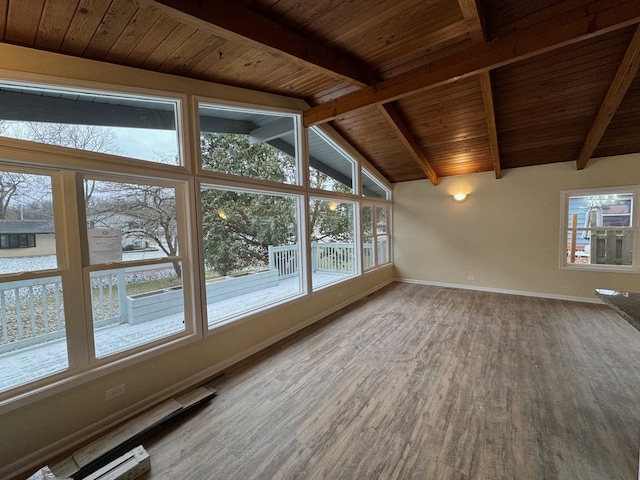 unfurnished sunroom featuring vaulted ceiling with beams, wood ceiling, and a wealth of natural light