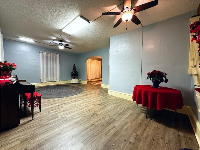 interior space featuring wood-type flooring, ceiling fan, and a textured ceiling