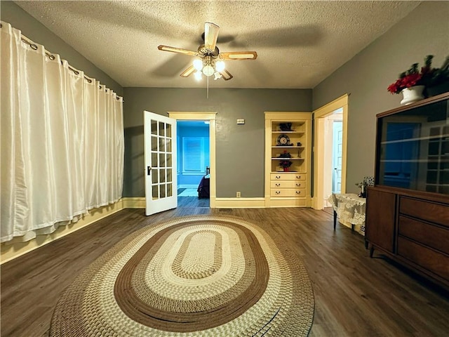 sitting room with ceiling fan, dark hardwood / wood-style floors, and a textured ceiling