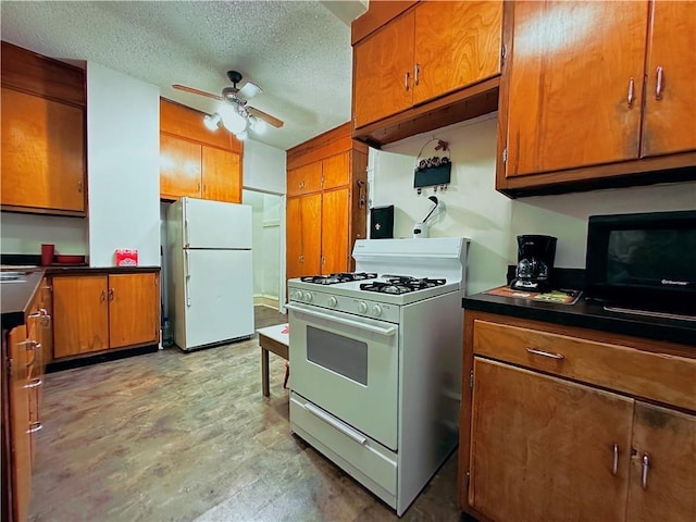 kitchen featuring ceiling fan, white appliances, and a textured ceiling