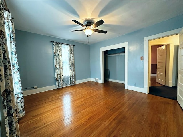 unfurnished bedroom featuring ceiling fan, wood-type flooring, and a closet