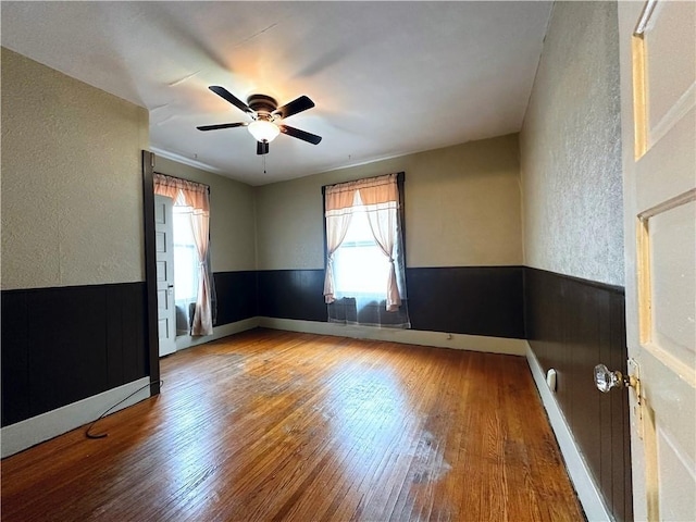 spare room featuring hardwood / wood-style floors, a healthy amount of sunlight, and ceiling fan