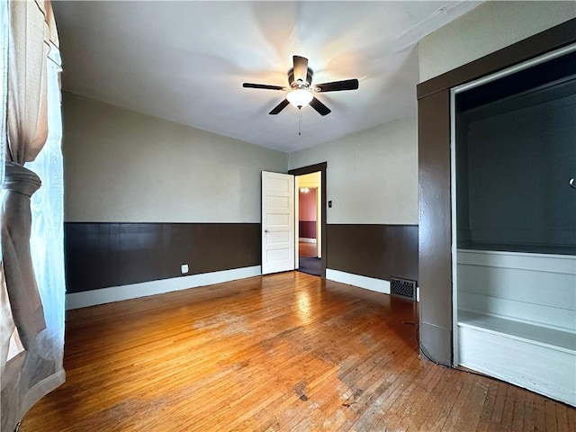 empty room with hardwood / wood-style flooring and ceiling fan