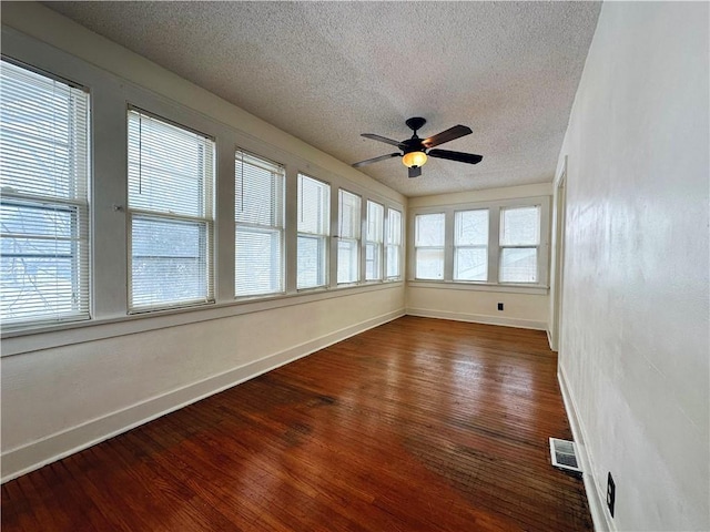 unfurnished sunroom featuring ceiling fan