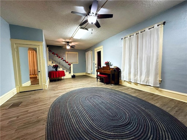 sitting room featuring ceiling fan, hardwood / wood-style floors, and a textured ceiling