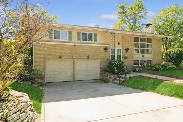 split foyer home with an attached garage, a chimney, concrete driveway, and brick siding