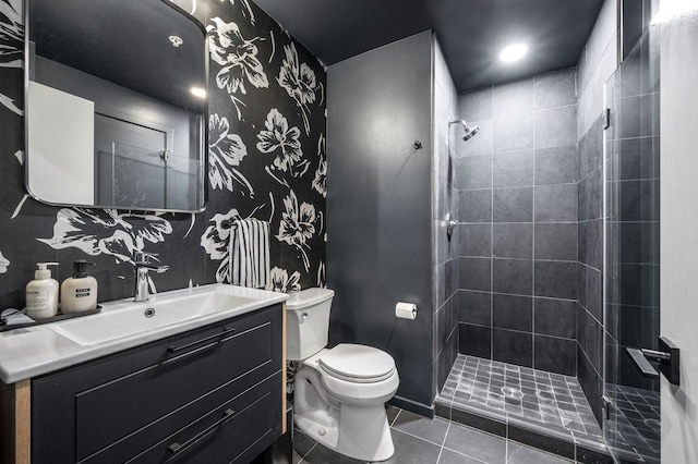 bathroom with vanity, tile patterned floors, toilet, and tiled shower