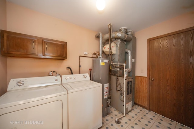 clothes washing area with washer and dryer, cabinets, and water heater