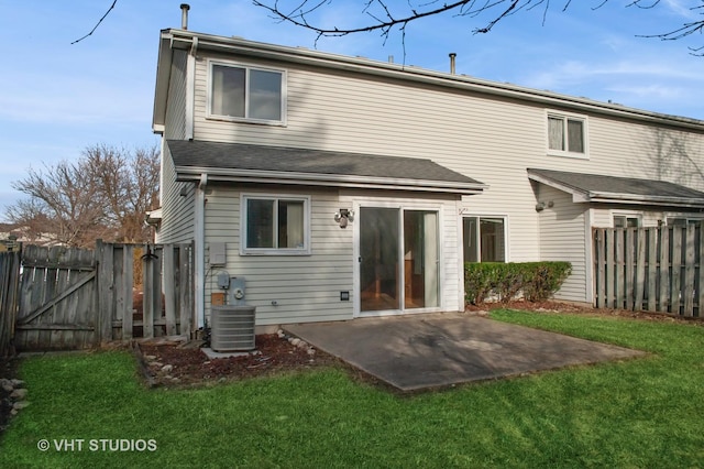 rear view of property featuring a lawn, a patio area, and central air condition unit