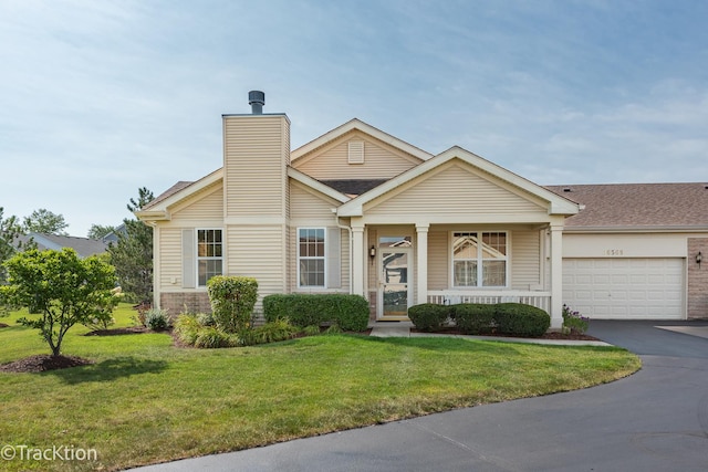 view of front of house with an attached garage, driveway, a chimney, and a front yard