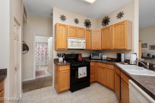 kitchen with white appliances, dark countertops, a sink, and a toaster