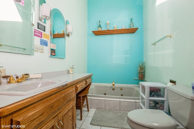 bathroom featuring tile patterned floors, vanity, toilet, and tiled bath