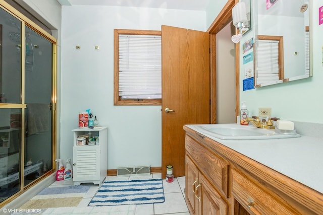 bathroom with tile patterned flooring, vanity, and a shower with door