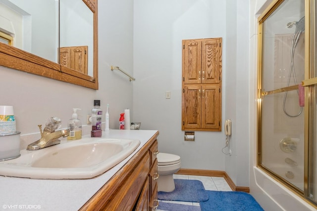 full bathroom with combined bath / shower with glass door, vanity, tile patterned flooring, and toilet