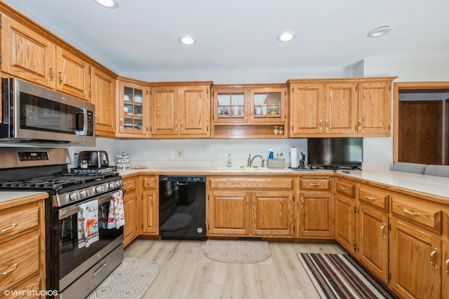 kitchen featuring light wood-type flooring, sink, and appliances with stainless steel finishes