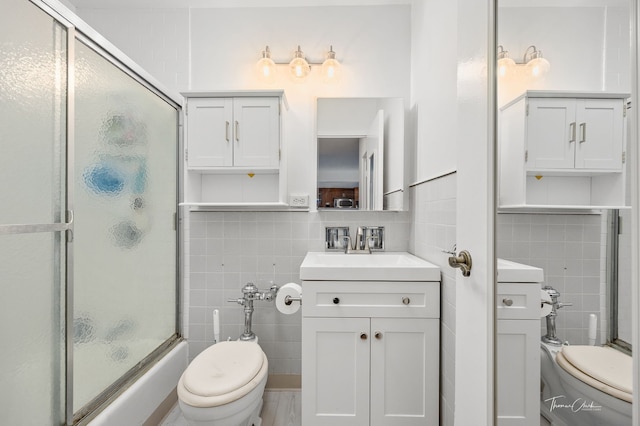 full bathroom featuring vanity, toilet, and tile walls