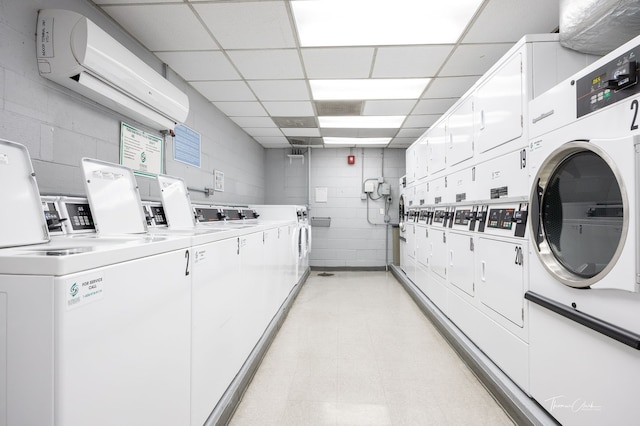 laundry area featuring stacked washer and clothes dryer, a wall mounted air conditioner, and washing machine and clothes dryer