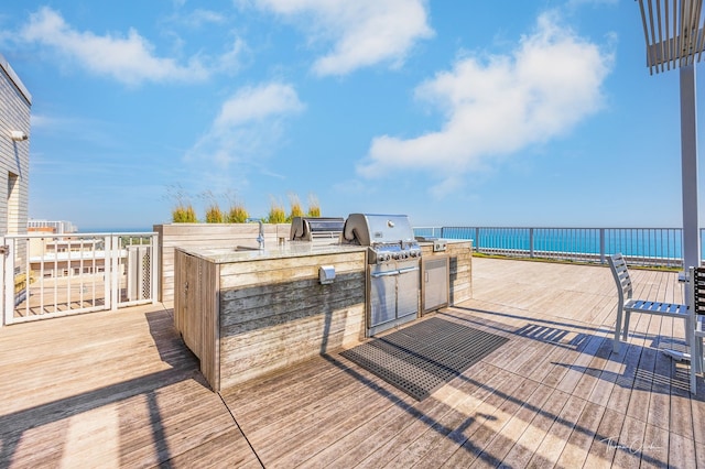 deck featuring a water view and area for grilling