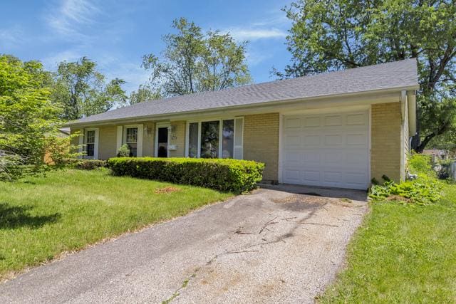 single story home featuring a front yard and a garage