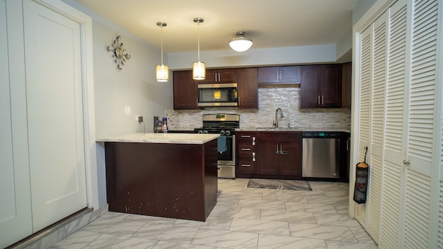 kitchen featuring sink, stainless steel appliances, backsplash, kitchen peninsula, and decorative light fixtures