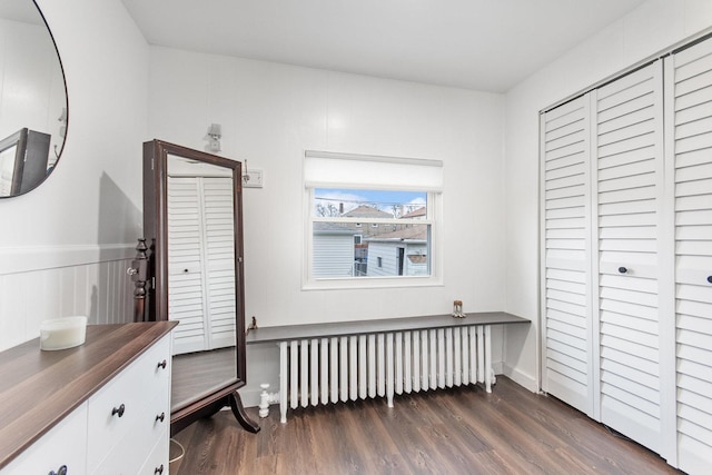 bedroom with radiator, a closet, and dark wood-type flooring