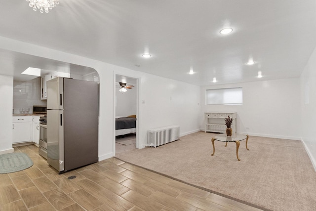 living room with ceiling fan, radiator heating unit, and light wood-type flooring