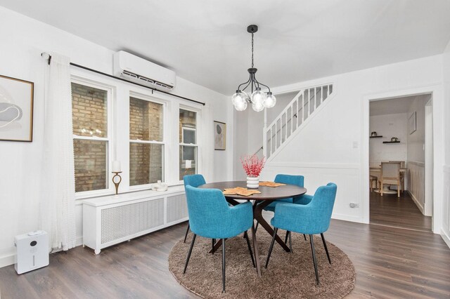 dining space with dark hardwood / wood-style flooring, an AC wall unit, radiator, and an inviting chandelier