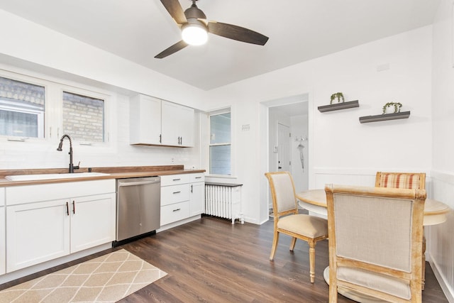 kitchen with white cabinetry, dishwasher, radiator heating unit, sink, and dark hardwood / wood-style floors