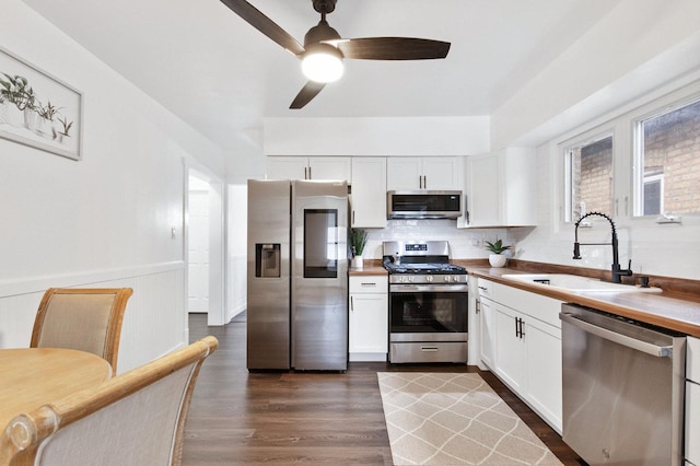 kitchen featuring white cabinets, appliances with stainless steel finishes, dark hardwood / wood-style floors, and sink