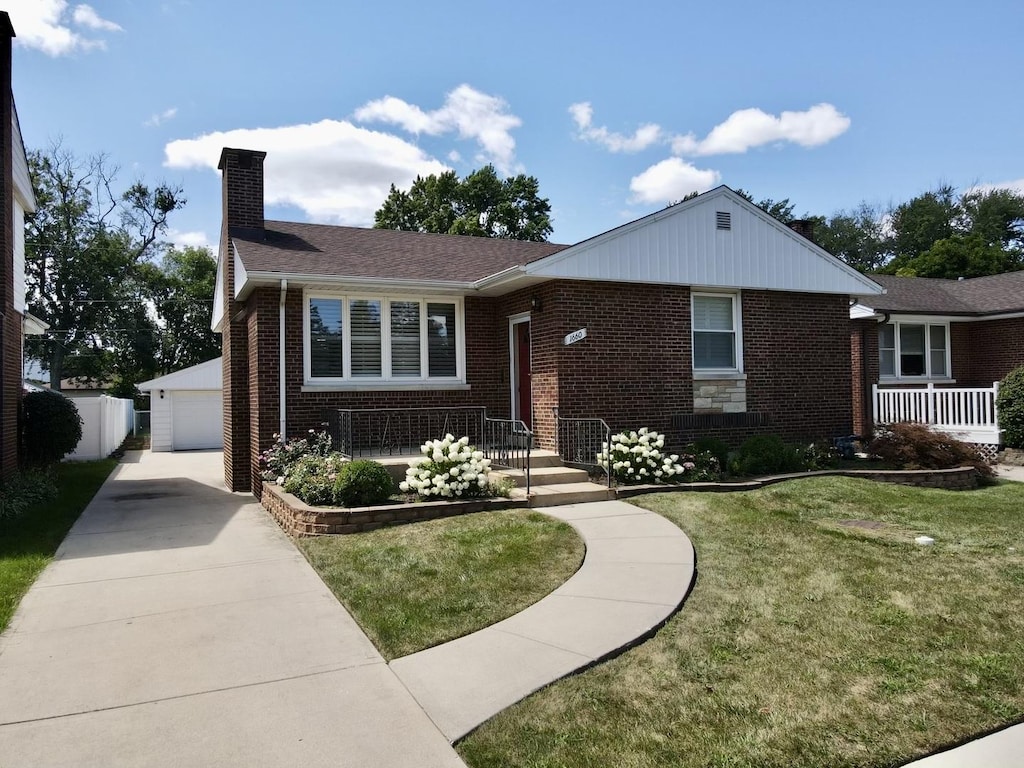 view of front facade featuring an outbuilding, a front lawn, and a garage