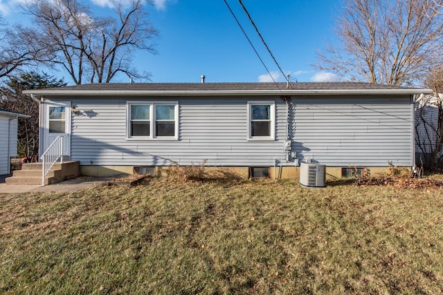 back of property featuring a lawn and cooling unit