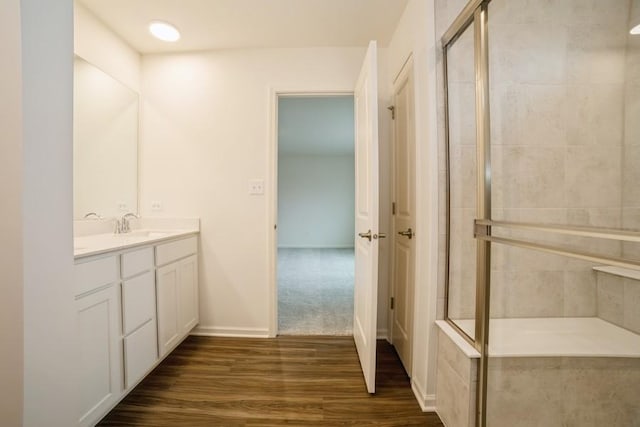 bathroom with vanity, hardwood / wood-style flooring, and a shower with shower door