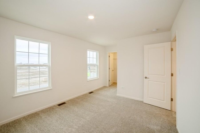 unfurnished bedroom with multiple windows and light carpet