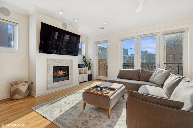 living room featuring hardwood / wood-style flooring, ceiling fan, and ornamental molding