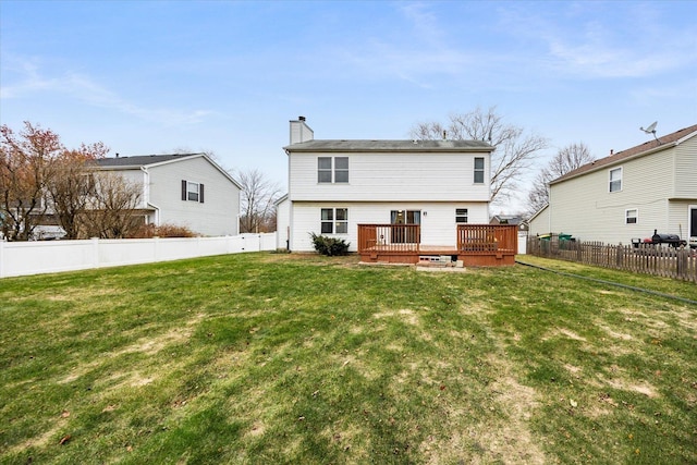 back of property with a lawn and a wooden deck