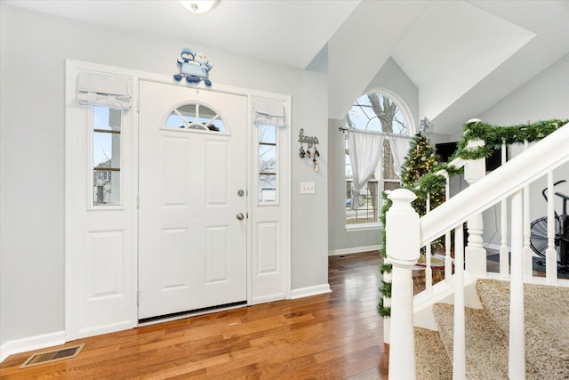 foyer featuring wood-type flooring and vaulted ceiling