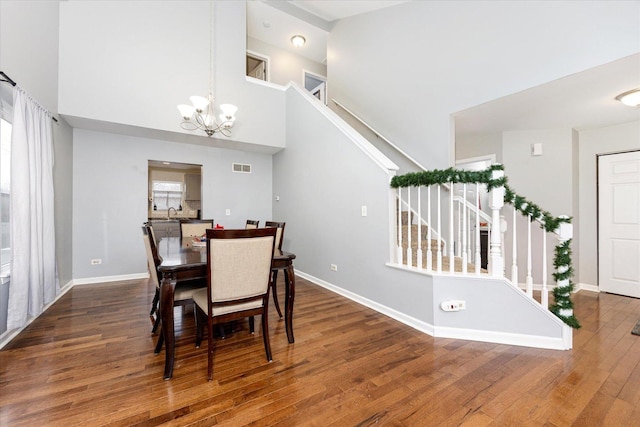 dining room with a chandelier, a high ceiling, dark hardwood / wood-style floors, and a wealth of natural light