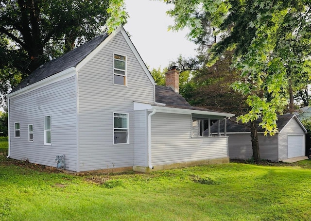 view of home's exterior featuring a garage, an outbuilding, and a yard