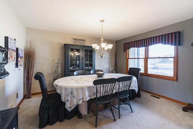 dining room with carpet and a chandelier