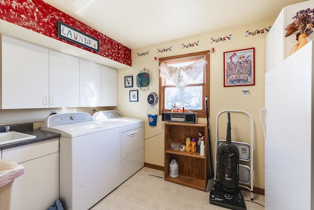 laundry area featuring cabinets, independent washer and dryer, and sink