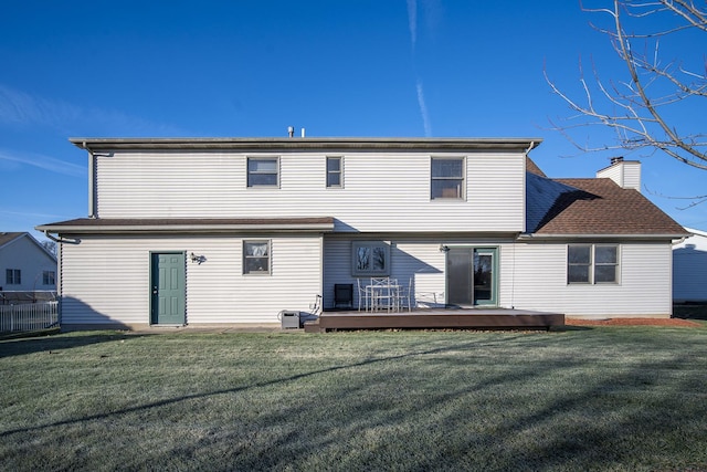 rear view of house with a lawn and a deck