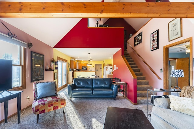 carpeted living room with ceiling fan, plenty of natural light, and lofted ceiling with beams