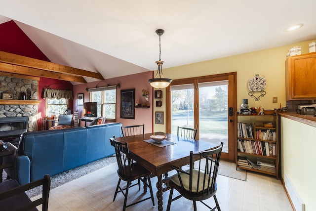 dining room with a fireplace and lofted ceiling