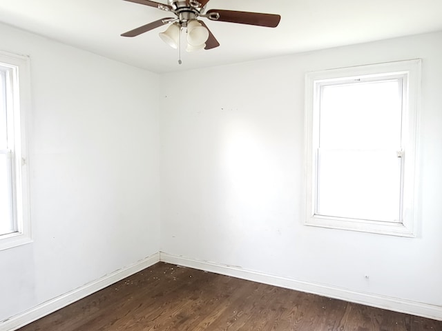 empty room with ceiling fan and dark wood-type flooring